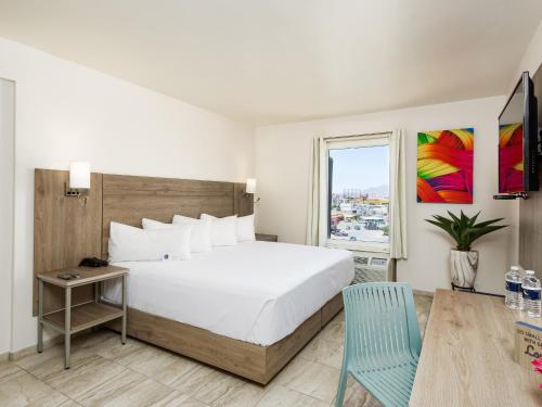 - une chambre avec un grand lit blanc et une fenêtre dans l'établissement Hotel Mesaluna Near American Consulate, à Ciudad Juárez