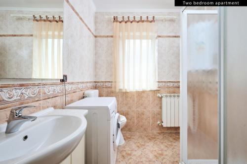 W łazience znajduje się umywalka, toaleta i prysznic. w obiekcie Apartments Angela w mieście Umag