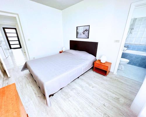 ein weißes Schlafzimmer mit einem Bett und einem Badezimmer in der Unterkunft The Martinez Holiday House - Zadar in Zadar