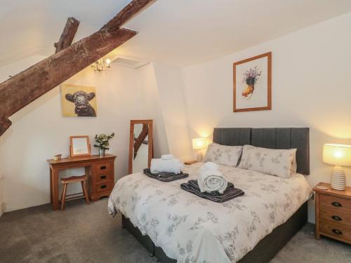 a bedroom with a bed and two night stands at 2 Pigsfoot Cottages in Tiverton