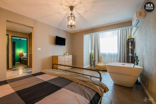 Un dormitorio con una cama, una bañera y un televisor. en Park Apartment 23, en Alba Iulia