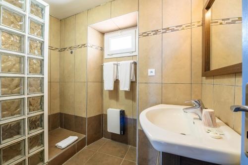 a bathroom with a sink and a shower at Hôtel Triton in Collioure
