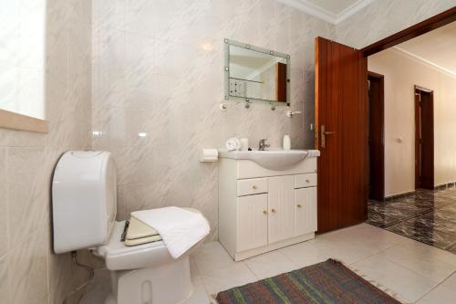 een badkamer met een toilet, een wastafel en een spiegel bij Nazaré Landscape in Nazaré