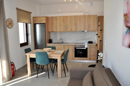 a kitchen and dining room with a wooden table and chairs at Alkioni's Nest Apartments in Arkoudi