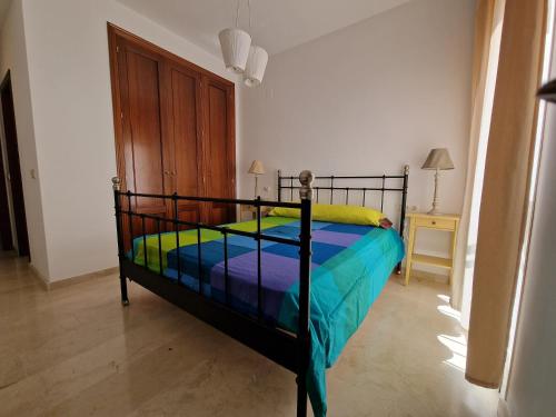 1 dormitorio con 1 cama con un edredón colorido en Apartamento La vida, en Málaga