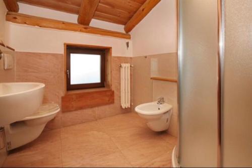 łazienka z umywalką, toaletą i oknem w obiekcie Hotel Derby Bar w mieście Sauze dʼOulx