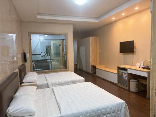 Habitación de hotel con 2 camas y TV en Can ho Muong Thanh, en Cửa Lô