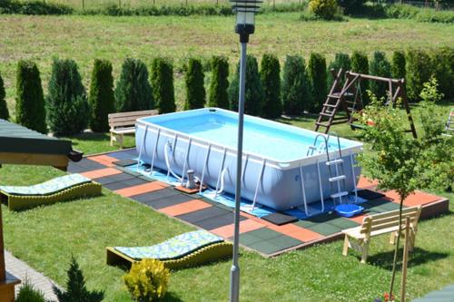 a swimming pool in a yard with a light pole at Domki Kazimierz in Darłowo