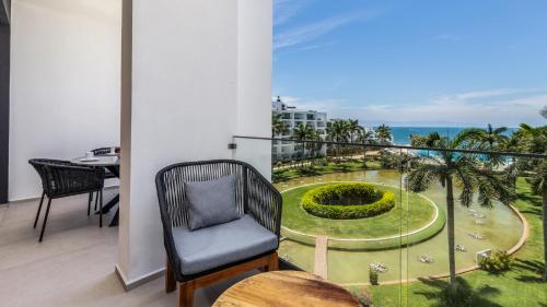 balcón con silla y vistas al jardín en Brand New Condo Aria Ocean 501 by Kivoya en Nuevo Vallarta 
