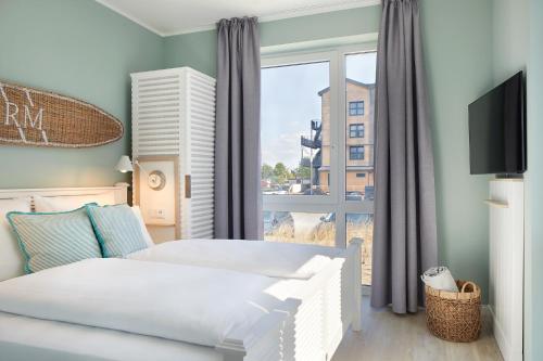 a bedroom with two beds and a window at Beach Apartments Büsum in Büsum