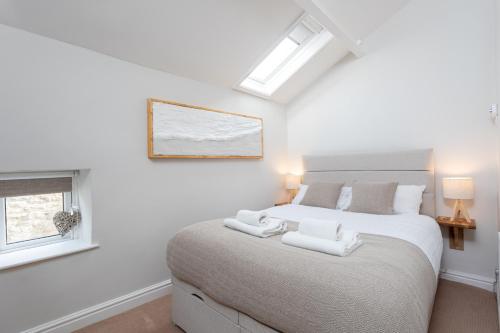 a bedroom with a large bed with two towels on it at Cobble Cottage in Richmond