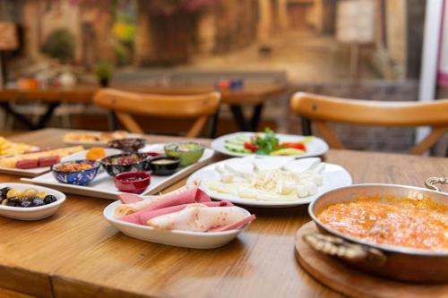 einem Holztisch mit Teller mit Lebensmitteln darauf in der Unterkunft Violette Mansion Oldcity in Istanbul