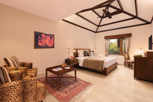 a bedroom with a bed and a couch and a table at Taj Corbett Resort and Spa Uttarakhand in Rāmnagar
