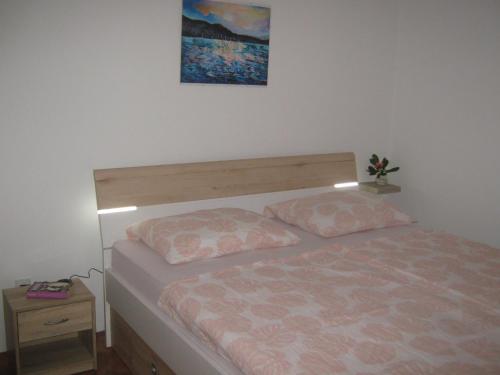 ein Schlafzimmer mit einem Bett und einem Bild an der Wand in der Unterkunft Matea in Crikvenica