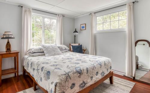 a bedroom with a bed and two windows at Cute Manzanita Beach House MCA 749 - Meredith Lodging in Manzanita