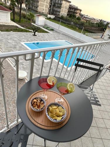 una mesa con comida y copas de vino en el balcón en Rosy's House, en Scafati