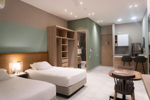 um quarto de hotel com duas camas e uma cozinha em FR Hotel em Ibagué