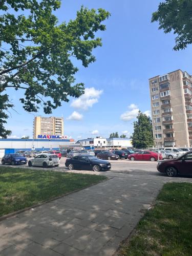 een parkeerplaats met auto's geparkeerd op een parkeerplaats bij Cozy Self Check-in CITY CENTRE apartment in Mažeikiai