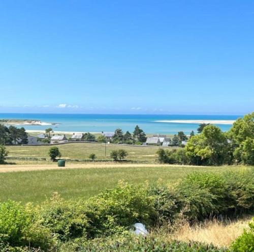 una vista del océano desde un campo en Maison familiale face à la mer, en Regnéville-sur-Mer