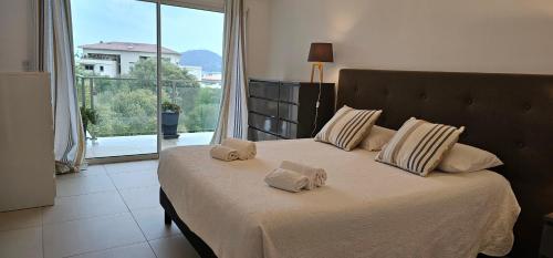 une chambre avec un lit avec deux serviettes dessus dans l'établissement Luxe et Confort à Porto-Vecchio, à Porto-Vecchio