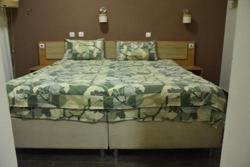 - une chambre avec un lit et une couette verte dans l'établissement Mps Lux Apartments, à Niš