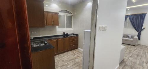 cocina con armarios de madera y encimera en وحدات جنان en Ahad Rafidah