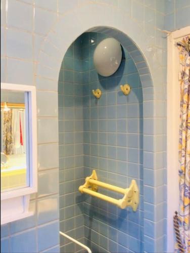 La salle de bains est pourvue de carrelage bleu, d'une douche et d'un miroir. dans l'établissement La Belle Vue - Duplex 6 pers, Face Mer & Parking, à Boulogne-sur-Mer