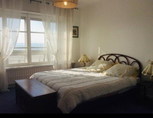une chambre avec un grand lit avec une fenêtre dans l'établissement La Belle Vue - Duplex 6 pers, Face Mer & Parking, à Boulogne-sur-Mer