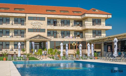 a hotel with a swimming pool in front of a building at Elektra Vama Veche in Vama Veche