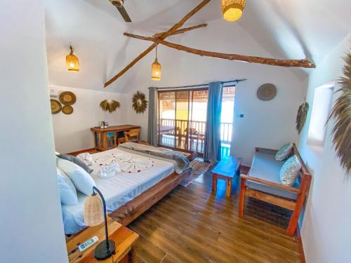 a bedroom with a bed and a table and a chair at Ananda Beach Hotel in Paje