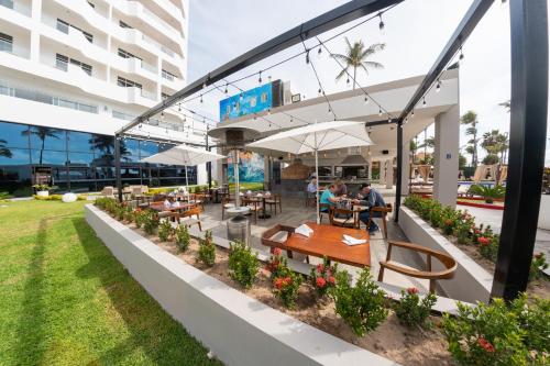 a restaurant with tables and umbrellas outside of a building at The Inn at Mazatlan in Mazatlán