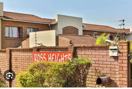 a brick wall with graffiti on it in front of a house at Ross Height Unit 16 in Richards Bay