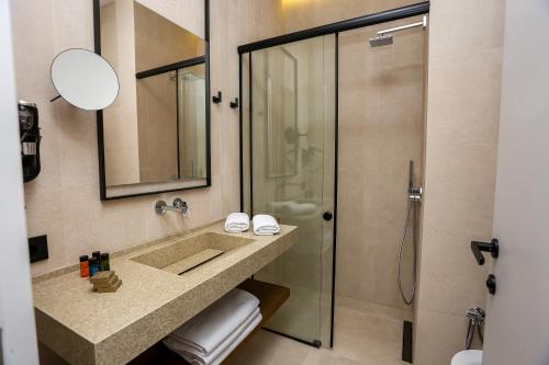 y baño con lavabo y ducha. en Nassau Hotel, en Dhërmi