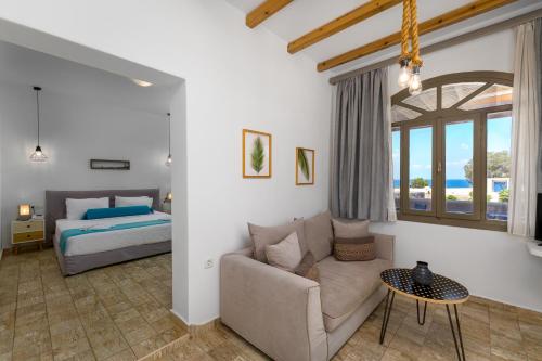 a living room with a couch and a bed at En Plo Boutique Suites Oia Santorini in Oia