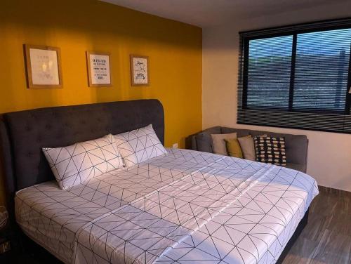 a bedroom with a bed with a purple comforter and a window at LUZ DE LUNA mesa de los santos house in Los Santos