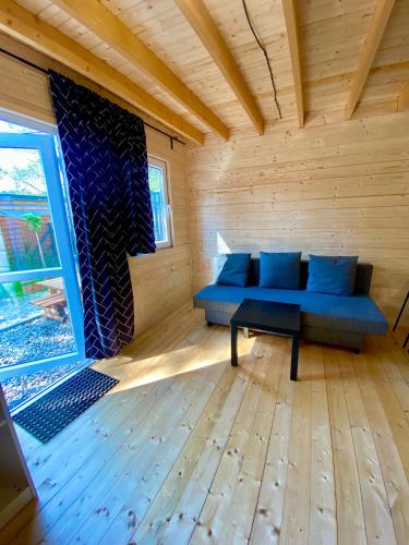 a living room with a blue couch and a table at Domy nad morzem- Family Resort - Chata Pirata 2 in Dziwnów