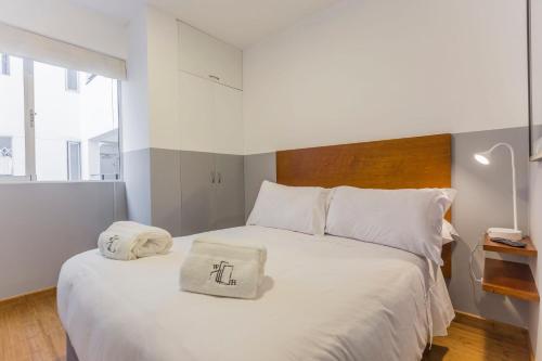 1 dormitorio con 1 cama blanca y 2 almohadas en Stylish 2BR in Miraflores, en Lima