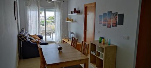 sala de estar con mesa, silla y comedor en APARTAMENTO LES CALES, en Vinarós