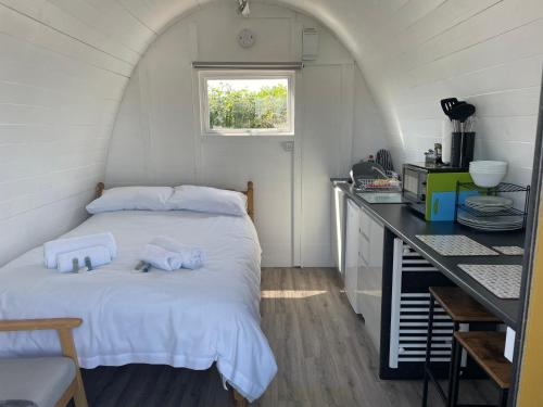 a bedroom with a bed with two towels on it at Cosy Glamping Pod with shared facilities, Nr Kingsbridge and Salcombe in Kingsbridge