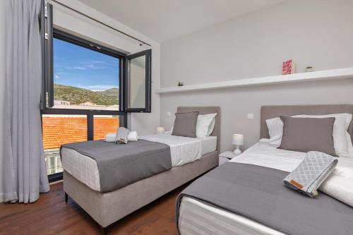 una camera con due letti e una grande finestra di Luxury Apartment N&P a Dubrovnik