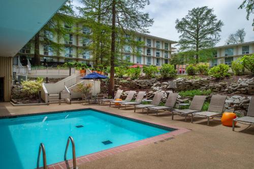 une piscine avec des chaises et un hôtel en arrière-plan dans l'établissement Marriott St. Louis Airport, à Edmundson