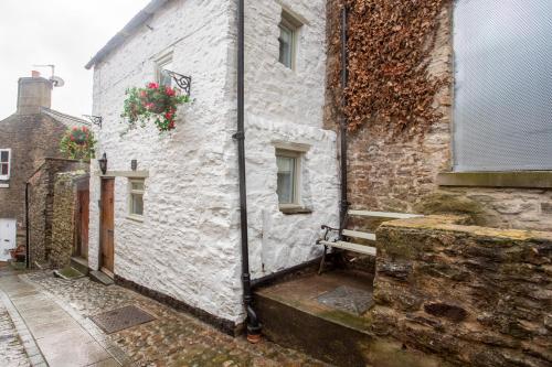 a white building with flowers on the side of it at Cobble Cottage in Richmond