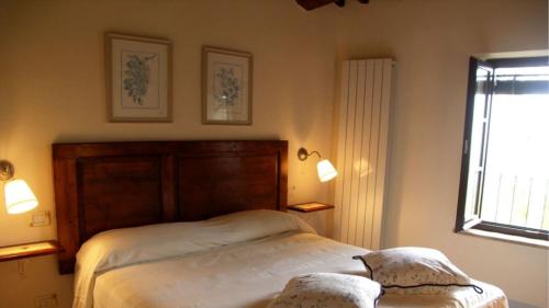 1 dormitorio con cama y ventana en Borgo di fighine, en San Casciano dei Bagni