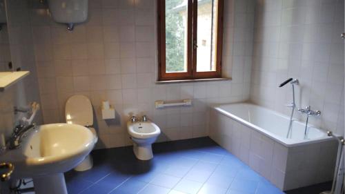 a bathroom with a toilet and a tub and a sink at Il tinaio in Monteroni dʼArbia
