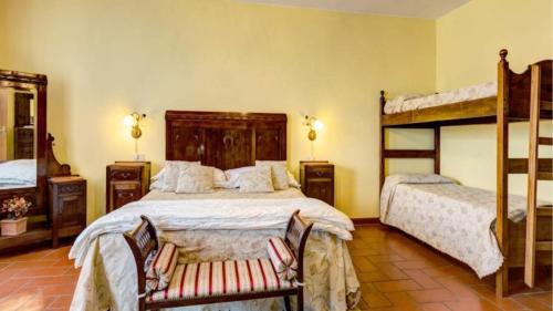 1 dormitorio con 2 literas y 2 sillas en Fattoria gli ziri, en Cortona