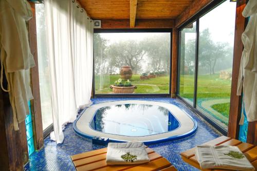 a jacuzzi tub in a room with a large window at Moraio in Collazzone