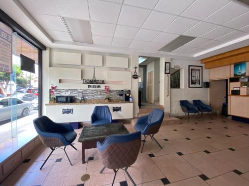 - une salle d'attente avec des chaises bleues et une table dans l'établissement Hotel Paris, à Tijuana