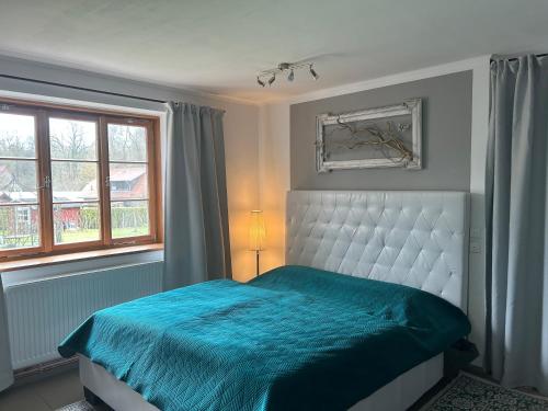 a bedroom with a blue bed and a window at Alte Küsterei Hohen Mistorf in Hohen Mistorf