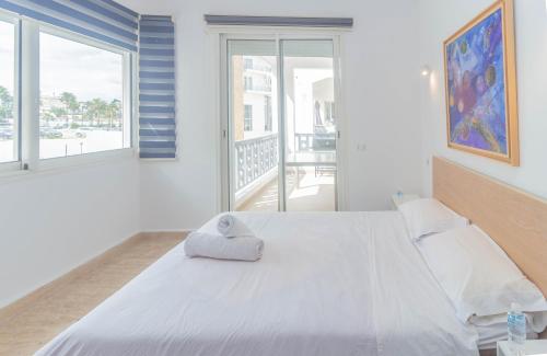 een slaapkamer met een groot wit bed en een balkon bij Appartement calme au bord de la mer in Tanger