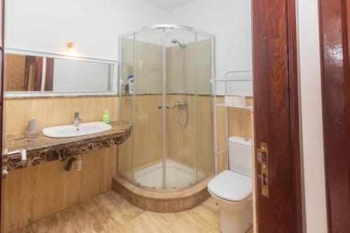een badkamer met een douche, een toilet en een wastafel bij Appartement calme au bord de la mer in Tanger